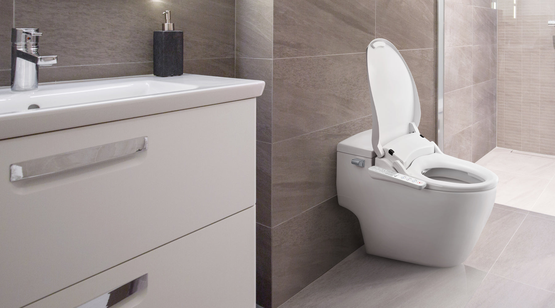 A Slim One bidet seat installed on a low, one-piece toilet in a gray-tiled bathroom.