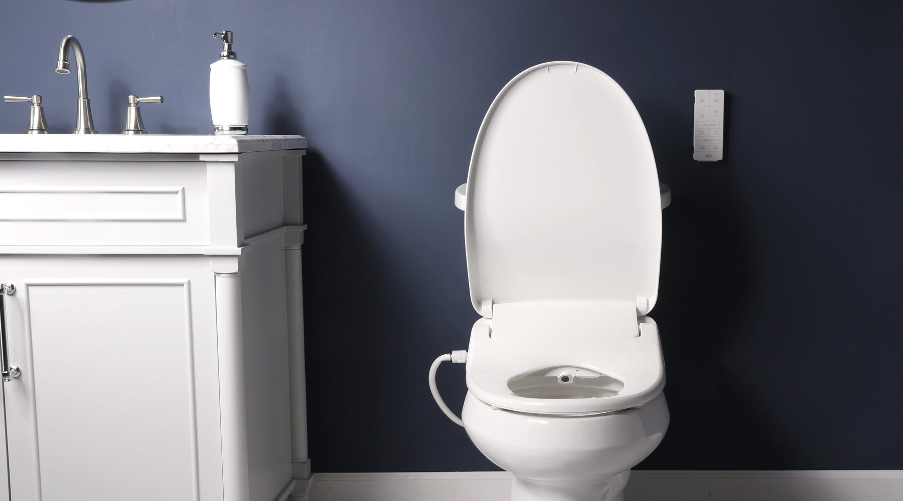 Front view of a toilet with an HD-7500 bidet toilet seat and a remote mounted to the wall behind.